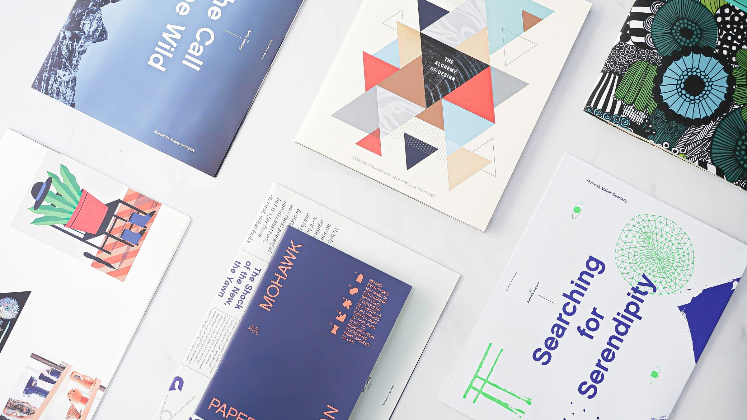 Printed design magazines with bold covers spread on a white table