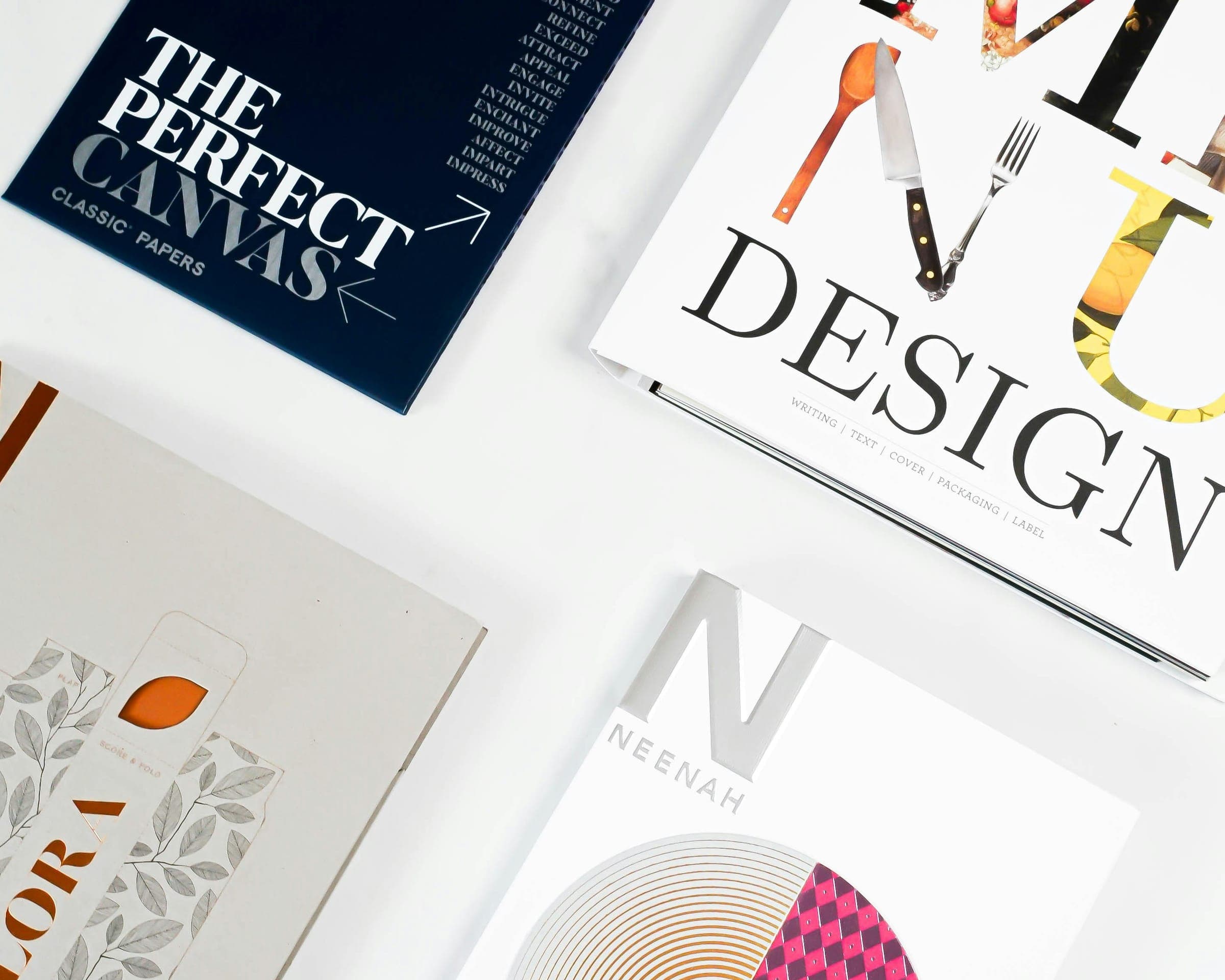 Paper sample books with elegant typographic covers on a white surface
